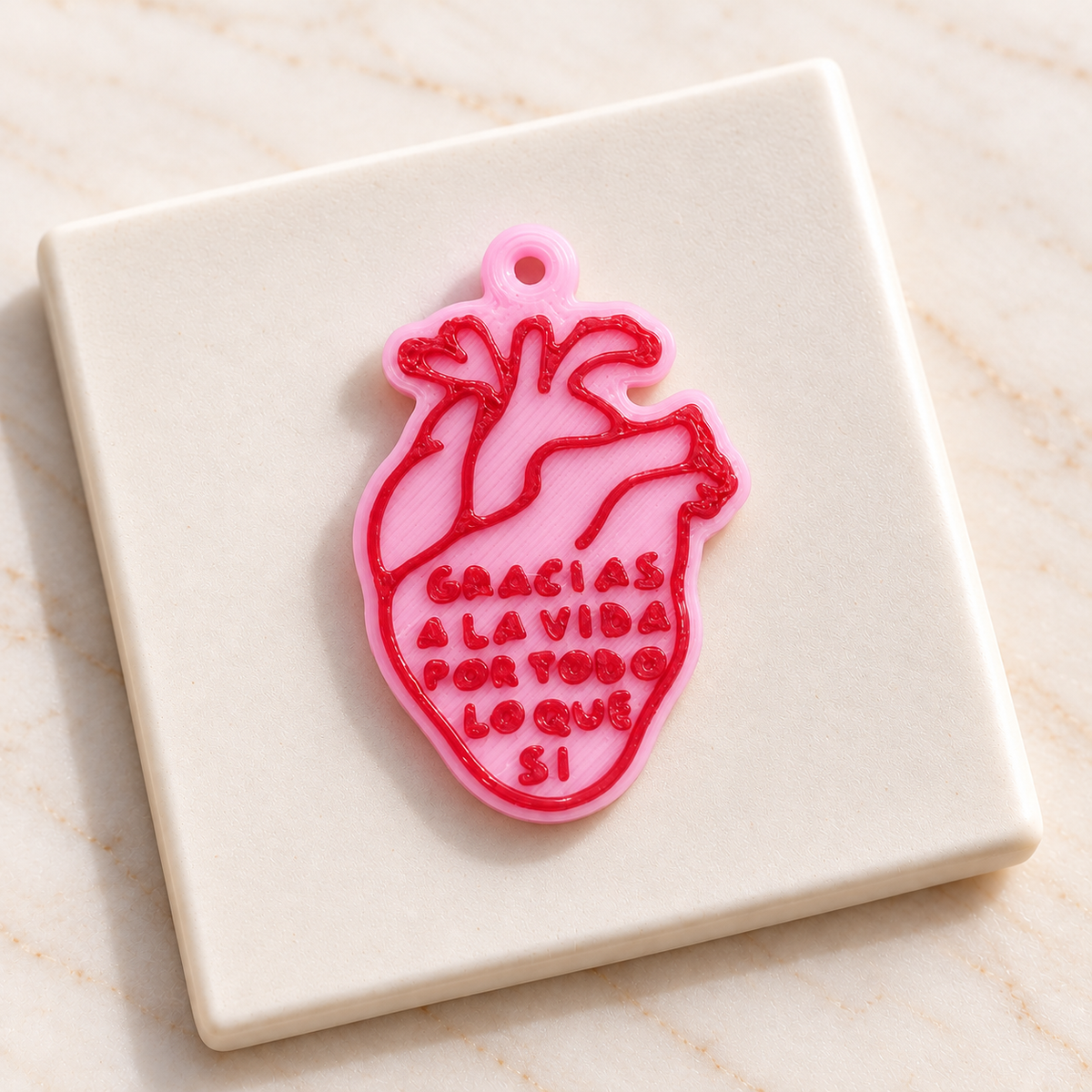 Dije corazón atómico frase